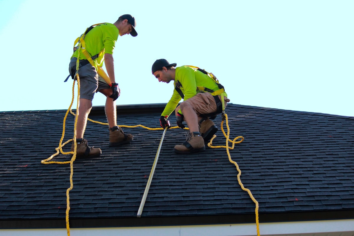 Roofing installers working on an asphalt shingle roof